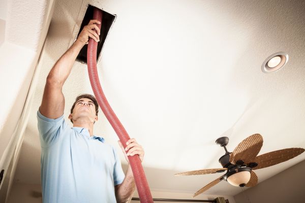 a technician cleaning air duct with vacuum cleaner 