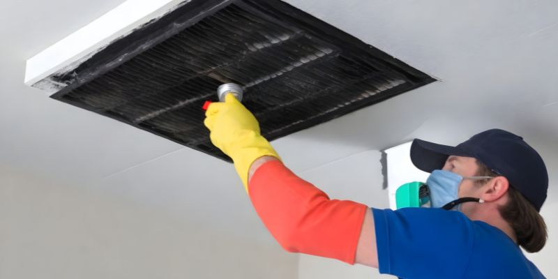 a technician cleaning air vent 